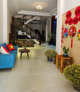 Dien Bien PhuFrontier Hostel & Tours的客厅设有蓝色的沙发和楼梯。