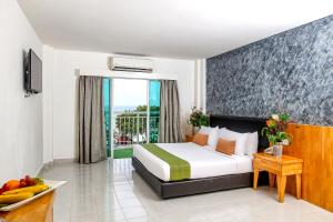 珍南海滩Langkapuri Resort Langkawi的酒店客房设有一张床和一个阳台。