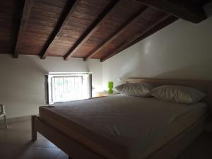 切齐纳码头Giacomo Home的一间卧室配有带两个枕头的床和窗户