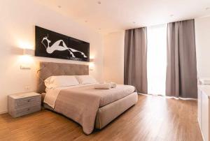 卡利亚里CeO LUXURY SUITE DI CAGLIARI的一间卧室设有一张床和一个大窗户