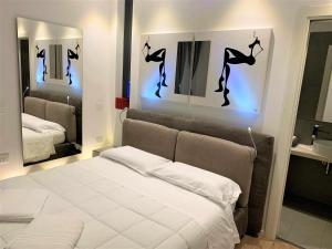 卡利亚里CeO LUXURY SUITE DI CAGLIARI的卧室配有白色的床和两面镜子