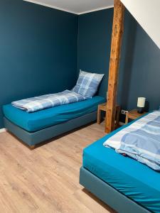 MarschkampFerienwohnung Haus Peters "De Groote"的蓝色的卧室,配有一张床和梯子