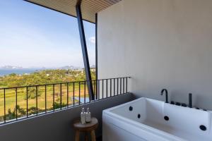 功孟海滩VARANA Hotel Krabi的带大窗的浴室内的白色浴缸