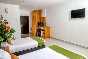 珍南海滩Langkapuri Resort Langkawi的酒店客房设有两张床和一台平面电视。
