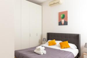 米兰Exclusive apartment Magritte Style的一间卧室配有带毛巾的床