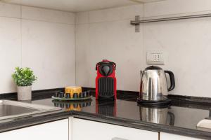 米兰Exclusive apartment Magritte Style的厨房台面上配有红色水壶