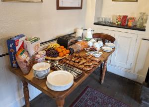 北安普敦Bartholomew Arms的一张木桌,上面有食物和盘子