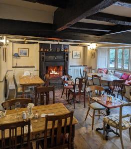 北安普敦Bartholomew Arms的一间带桌椅和壁炉的餐厅