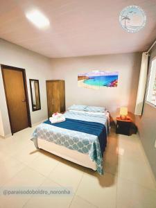 费尔南多 - 迪诺罗尼亚Paraíso do Boldró Flat的一间卧室配有一张带蓝色棉被的床