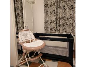 奥斯特西巴德钦诺维茨Ferienwohnung Zinnowitz USE 1501的客房内的婴儿床和高脚椅