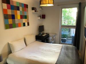 柏林Best Apartment in the Center of Berlin with Big Terrace的一间卧室配有一张带书桌的床和窗户。
