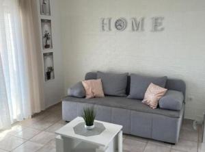 罗戈兹尼察Apartment Megi的客厅配有沙发和墙上的爱情标志
