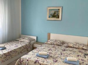 罗戈兹尼察Apartment Megi的卧室内的两张床,墙上挂着一幅画