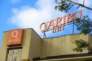 内罗毕Qaribu Inn Boutique Hotel Nairobi的建筑物顶部的标志