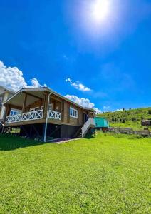 BesqaynarДомик в горах的天空中阳光灿烂的草地上的房子