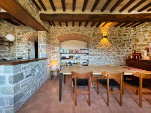 卡普雷塞·米开朗基罗比奥伊尔维尼欧农庄酒店的一间带木桌和椅子的用餐室