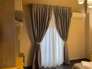 维亚雷焦卢卡斯酒店的卧室内带窗帘的窗户