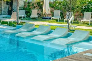 阿默达拉-伊拉克利翁Georgia's Garden by Omilos Hotels的一组椅子和一个游泳池