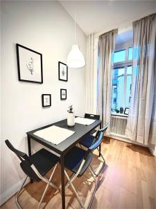 哥德堡Luxury Apartment In City Centre的一间带桌椅和窗户的用餐室
