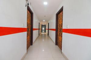 新德里FabExpress Abode Inn的建筑中一条有红色和白色墙壁的走廊