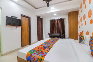 新德里FabExpress Abode Inn的一间卧室设有一张大床和一台墙上的电视。