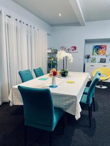 皇后镇Kelvin Garden Villa的一张带蓝色椅子和白色桌布的餐桌