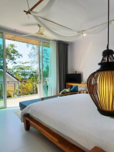 塔可克海滩甲米之家度假酒店的一间卧室设有一张大床和一个大窗户