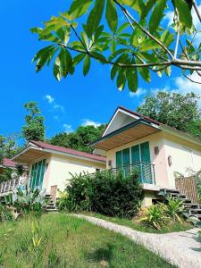 塔可克海滩甲米之家度假酒店的绿色百叶窗和门廊的房子