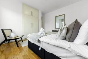伦敦1 Bedroom Apartment - Mayfair (6)的一间卧室配有一张大床和一把椅子