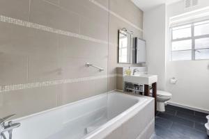 伦敦1 Bedroom Apartment - Mayfair (6)的白色的浴室设有浴缸和卫生间。