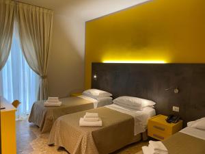 维亚雷焦卢卡斯酒店的酒店客房,配有三张床和毛巾