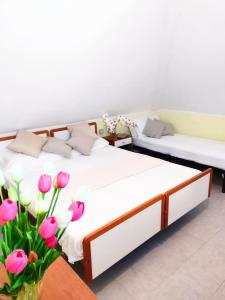 切塞纳蒂科Hotel Ambasciata的配有两张床的客房,拥有粉红色的鲜花