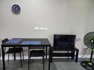 Cozy 1-bedroom apartment in Frequente, St. George的一张黑桌子和椅子,墙上挂着一个钟
