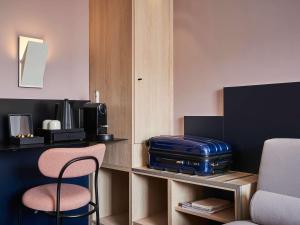 巴黎巴黎凡尔赛15号美居酒店的配有带手提箱和椅子的书桌的房间