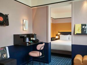 巴黎巴黎凡尔赛15号美居酒店的酒店客房配有一张床和一张带椅子的书桌