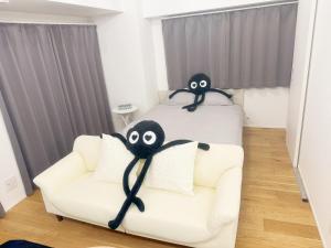 东京山手線恵比寿8分　4人可　的一间卧室配有沙发和一张带眼 ⁇ 的床