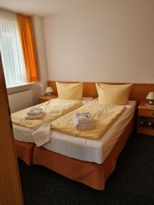 SchönkirchenArp's Gasthof的一间卧室配有一张床,上面有两条毛巾