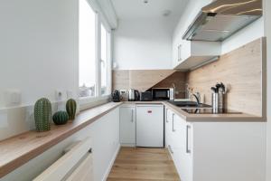 里尔Lille Centre - Nice cozy and functional ap的厨房配有白色橱柜和窗户。