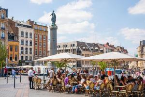 里尔Lille Centre - Nice cozy and functional ap的一群坐在城市桌子上的人