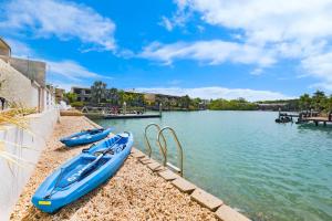 达尔文'Infinity's Edge' Darwin Luxury Waterfront Oasis的两艘蓝色的船在河岸上