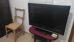 罗萨里奥港Laurainu的电视坐在架子上,配有椅子和椅子