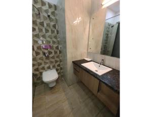 安巴拉Hotel Sobti Plaza, Ambala, Haryana的一间带水槽、卫生间和镜子的浴室