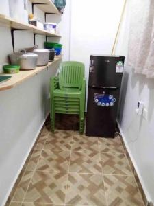 KakamegaZen House的厨房里冰箱旁的绿色椅子