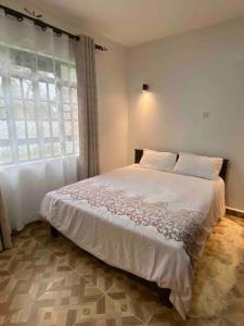KakamegaZen House的卧室配有一张大白色床和窗户