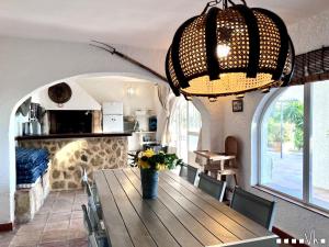 莫莱拉VH CostaBlanca - TRES PALMERAS的一间带木桌和吊灯的用餐室