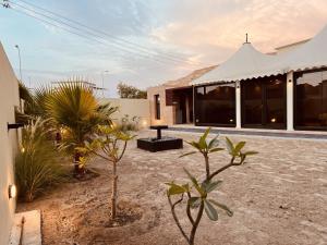 马斯喀特ONE Elegant Cottage near the Beach的一座房子前面有种有植物的庭院