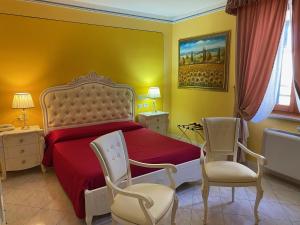 拉戈堡拉托雷酒店的一间卧室配有红色的床和两把椅子