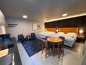 雷克雅未克云游客栈的酒店客房带两张床和一张桌子以及椅子。