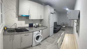 马拉加Apartamento Tejares 2B的厨房配有白色橱柜、洗衣机和烘干机