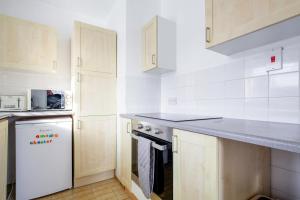 切斯特Chester Stays - Best Value Apartment with Free Parking in the heart of Chester的厨房配有白色橱柜和白色冰箱。